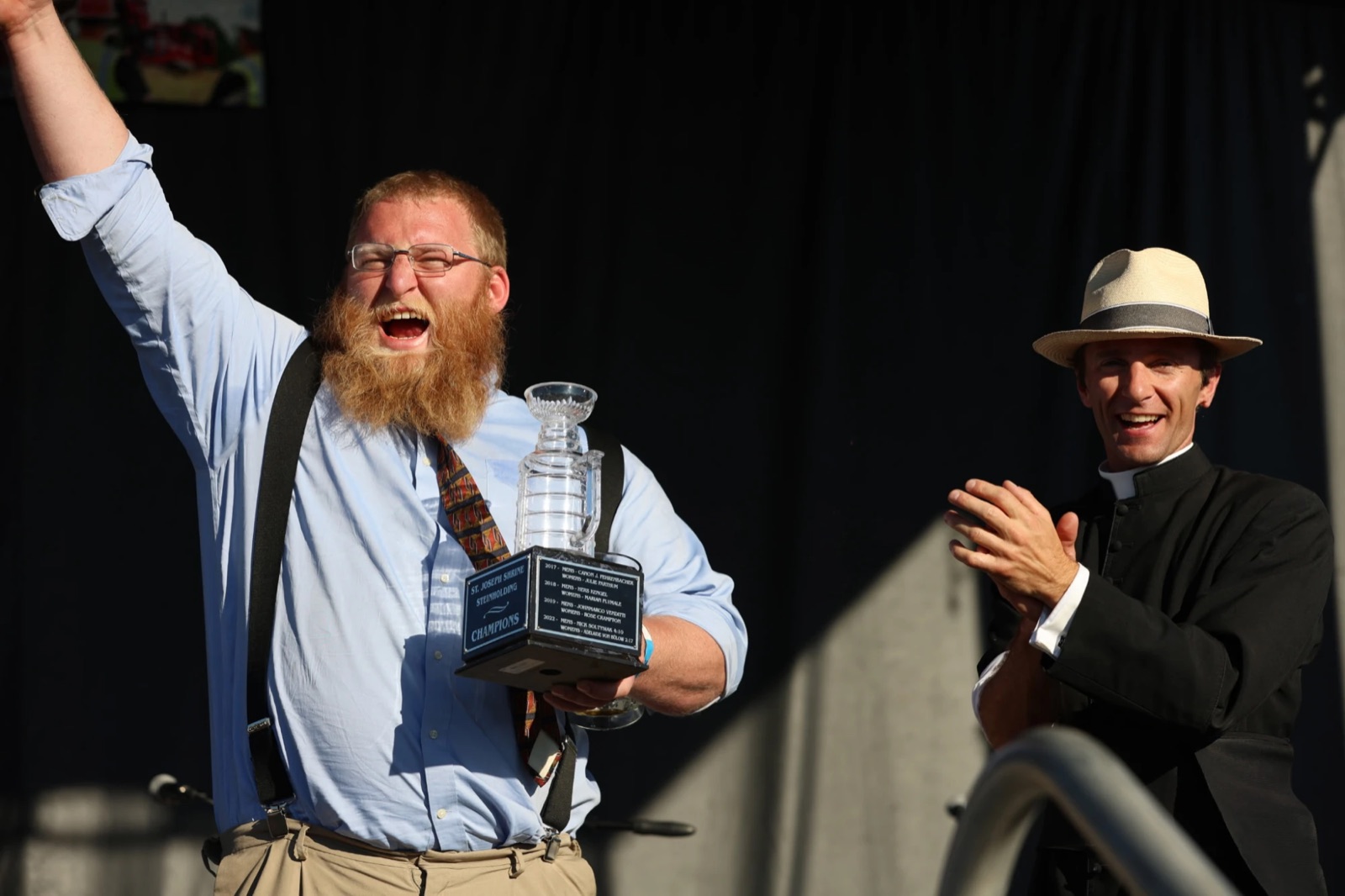 Jack Carter, 2026 men's champion, raising his arm in victory while holding the Steinly Cup as Canon applauds