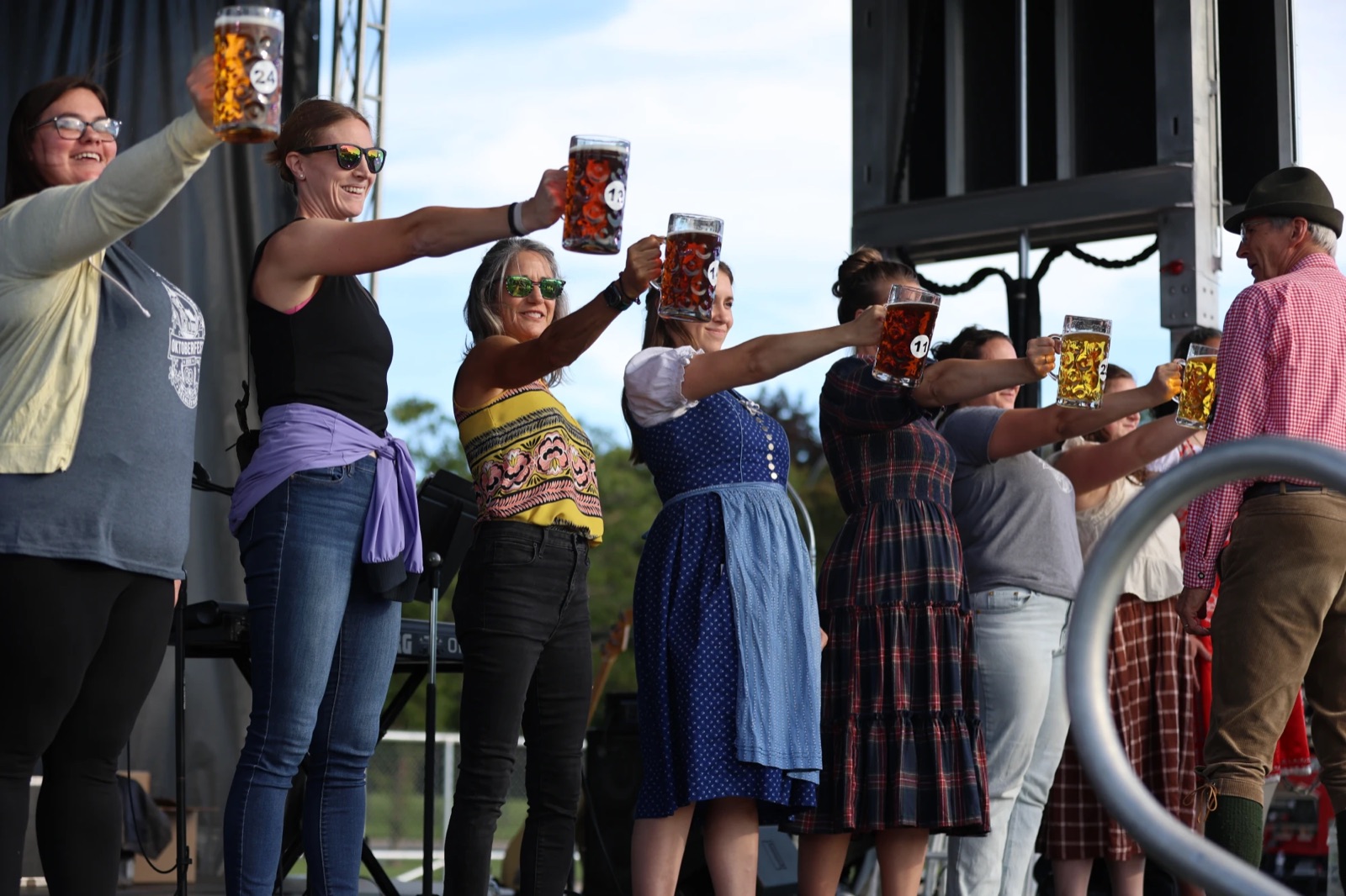 Women's division competitors holding steins on stage