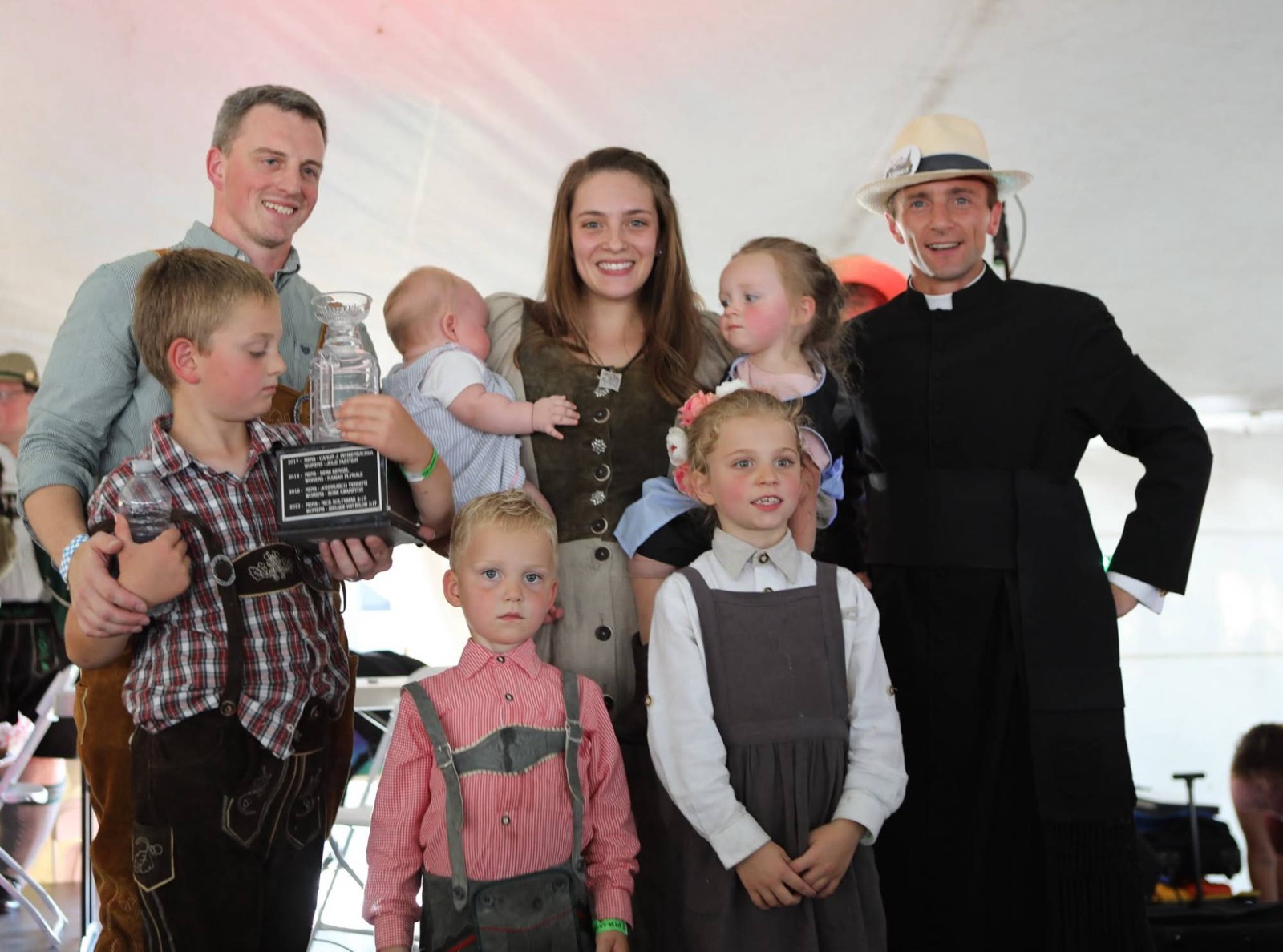 A family in traditional dress posing with the Steinly Cup and the Canon
